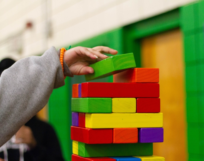 Child playing with wooden, coloured building blocks
