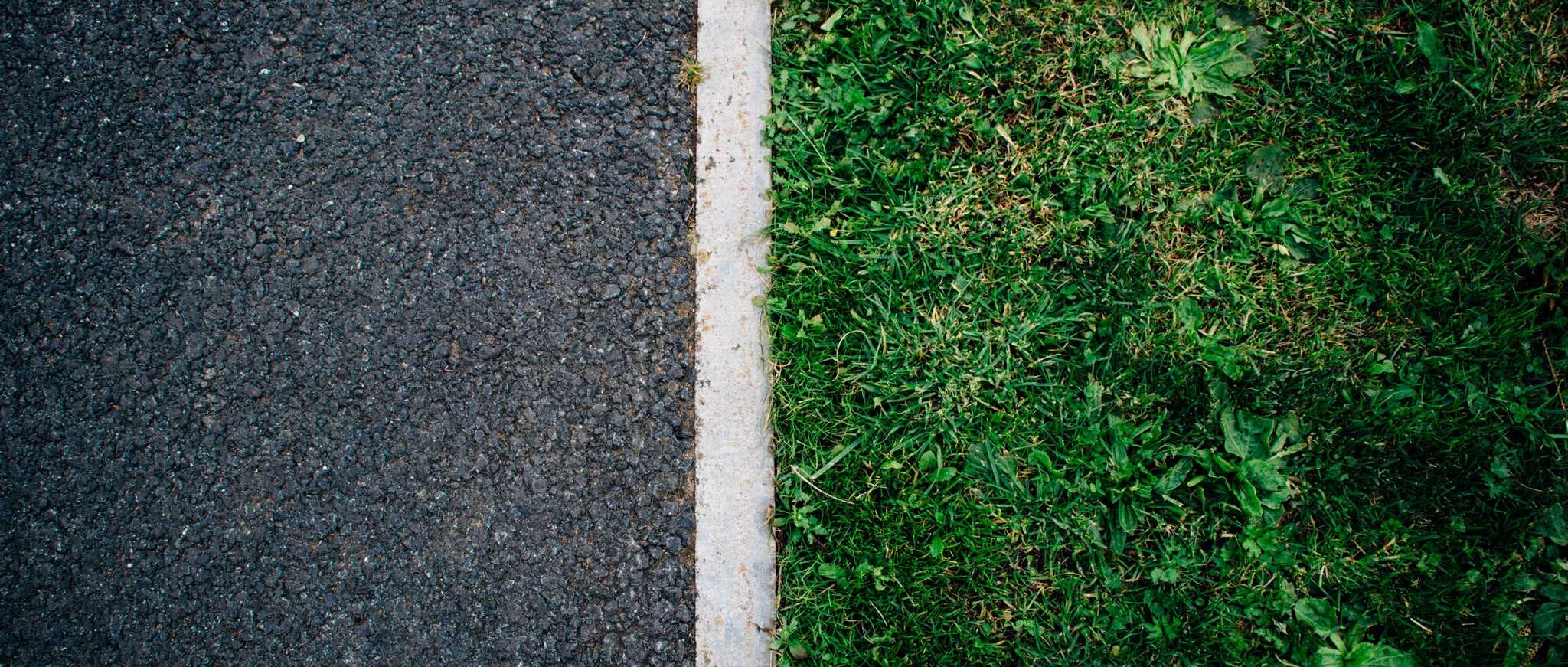 A lawn and a road clearly separated by a curb